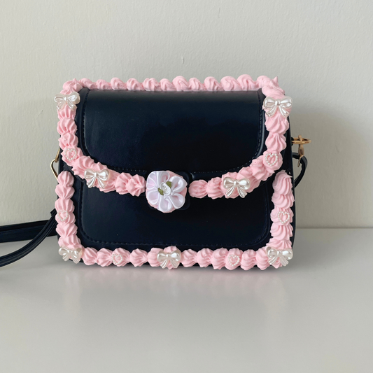 Black purse that looks like a fake cake with adjustable straps